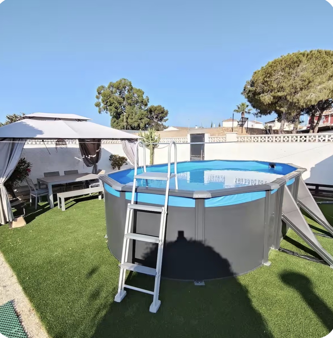 Piscina elevada en el jardín con pérgola y césped